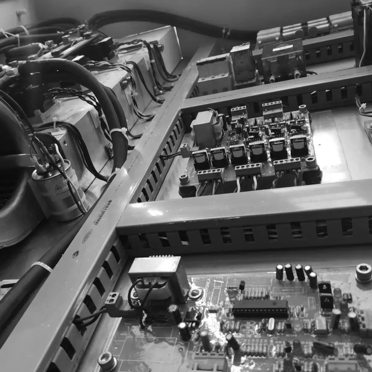 Interior del gabinete: transformador, ventilador centrífugo, capacitores y tarjetas electrónicas de control montadas sobre placa, con el cableado en canaletas.